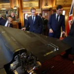 مسؤولون أوكرانيون وأميركيون وبريطانيون يقفون في مبنى البرلمان بالعاصمة لندن بجانب طائرة مسيرة