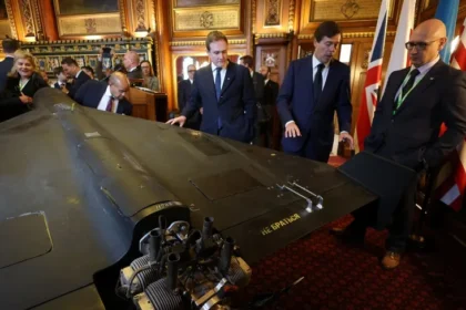 مسؤولون أوكرانيون وأميركيون وبريطانيون يقفون في مبنى البرلمان بالعاصمة لندن بجانب طائرة مسيرة