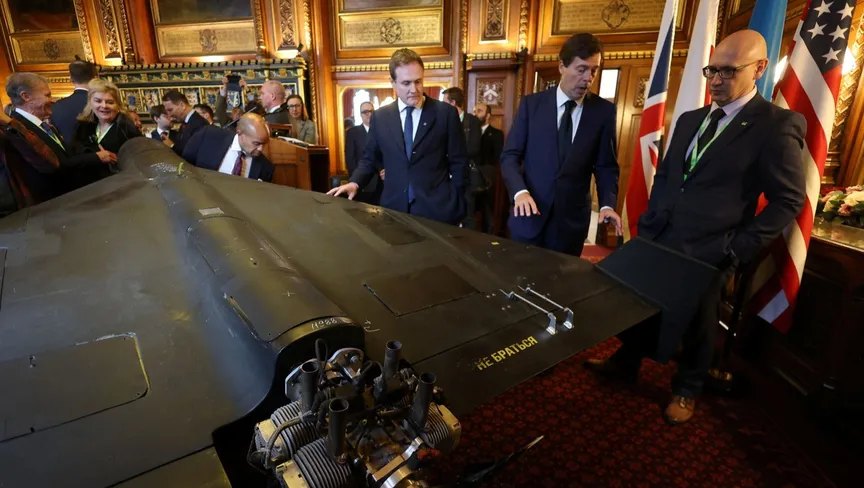 مسؤولون أوكرانيون وأميركيون وبريطانيون يقفون في مبنى البرلمان بالعاصمة لندن بجانب طائرة مسيرة