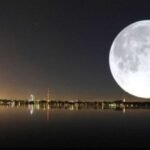 ما هو "القمر البارد"؟ وداع استثنائي لظواهر 2025 الفلكية تستعد سماء العالم العربي، ومعظم أنحاء نصف الكرة الشمالي، لاستقبال آخر ظاهرة "قمر عملاق" لعام 2025، وهو القمر المعروف تقليدياً باسم "القمر البارد" (Cold Moon). يمثل هذا الحدث الفلكي نهاية سلسلة من الظواهر القمرية المذهلة التي زينت سماء العام، ويأتي بالتزامن مع اكتمال بدر شهر جمادى الآخرة لعام 1447 هجري. ماذا يعني "القمر العملاق"؟ يُطلق مصطلح "القمر العملاق" على ظاهرة تحدث عندما يتزامن اكتمال القمر (البدر) مع وصوله إلى أقرب نقطة له من الأرض في مداره، وهي النقطة المعروفة فلكياً باسم "الحضيض القمري". نتيجة لهذا التقارب، يبدو القمر أكبر حجماً بنسبة تصل إلى 14% وأكثر إشراقاً بنسبة 30% مقارنة بأبعد نقطة له في المدار. ويُعد "القمر البارد" أعلى بدر في سماء نصف الكرة الشمالي خلال عام 2025، وهو ما يجعله مشهداً لا يُنسى، خاصةً مع اقتراب موعد الانقلاب الشتوي. 2. لماذا سُمي بـ "القمر البارد"؟ الجذور التاريخية والتسميات تأتي تسمية "القمر البارد" من الثقافات الأمريكية الأصلية والأوروبية القديمة، حيث كان يُطلق هذا الاسم على البدر المكتمل الذي يظهر في شهر ديسمبر، تزامناً مع بداية فصل الشتاء وانخفاض درجات الحرارة. هذه التسمية لا ترتبط بدرجة حرارة القمر نفسه، بل بالطقس البارد الذي يسود الأرض خلال فترة ظهوره. أهمية الظاهرة: • الاقتراب القياسي: سيصل القمر إلى نقطة الحضيض على مسافة تُقدر بنحو 356,846 كيلومتراً من الأرض، وهو ما يفسر حجمه وضياءه الاستثنائيين. • آخر وداع: يمثل هذا القمر العملاق البدر الثاني عشر والأخير في عام 2025، مما يجعله فرصة أخيرة لعشاق الفلك للاستمتاع بهذه الظاهرة قبل حلول العام الجديد. 3. دليل المشاهدة: كيف ومتى تشاهد القمر البارد؟ للاستمتاع بأفضل رؤية لظاهرة "القمر البارد"، لا تحتاج إلى تلسكوب أو معدات فلكية متخصصة، حيث يمكن رؤيته بالعين المجردة بوضوح. نصائح المشاهدة: 1. التوقيت الأمثل: يبدأ القمر في الظهور بشكل واضح مساء يوم الخميس 4 ديسمبر، ويصل إلى ذروة اكتماله وإشراقه في الساعات الأولى من الليل. 2. الموقع: يفضل التوجه إلى مكان بعيد عن أضواء المدن والتلوث الضوئي، حيث تكون السماء أكثر صفاءً. 3. وهم القمر (Moon Illusion): للحصول على أفضل تأثير بصري، حاول مشاهدة القمر عند شروقه أو غروبه، وهو قريب من الأفق. في هذه اللحظة، يبدو القمر أكبر حجماً بشكل ملحوظ بسبب مقارنته بالعناصر الأرضية مثل المباني والأشجار، وهي ظاهرة تُعرف باسم "وهم القمر". 4. كيف تلتقط أفضل صورة للقمر العملاق بهاتفك؟ (دليل HubSpot للتصوير) يواجه الكثيرون صعوبة في تصوير القمر العملاق بالهاتف المحمول، حيث يتحول القمر غالباً إلى "بقعة بيضاء" ساطعة. إليك دليل احترافي لالتقاط صور مذهلة: 1. تجنب التكبير الرقمي (Digital Zoom): التكبير الرقمي يقلل من جودة الصورة. إذا كان هاتفك يحتوي على عدسة تقريب بصري (Optical Zoom)، استخدمها. 2. استخدام وضع "الاحترافي" (Pro Mode): قم بتفعيل الوضع الاحترافي في كاميرا هاتفك للتحكم في الإعدادات يدوياً: • تقليل حساسية الضوء (ISO): اضبطها على أقل قيمة ممكنة (عادة 50 أو 100) لتقليل الضوضاء. • تقليل سرعة الغالق (Shutter Speed): استخدم سرعة غالق عالية (مثل 1/125 ثانية) لتثبيت الصورة. • تقليل التعريض (Exposure Compensation): قم بتقليل قيمة التعريض (EV) بشكل كبير لكي لا يتحول القمر إلى بقعة بيضاء. 3. التصوير عند الشفق: وفقاً لوكالة ناسا، يُعد وقت الشفق (بعد الغروب مباشرة) خياراً مثالياً. في هذا الوقت، لا تزال السماء مضاءة قليلاً، مما يقلل من التباين الكبير في الإضاءة بين القمر والسماء، ويساعد الهاتف على التقاط التفاصيل. 4. استخدام حامل ثلاثي (Tripod): للحصول على صورة حادة وواضحة، يجب تثبيت الهاتف تماماً لتجنب أي اهتزاز. 5. تداعيات الظاهرة: ما وراء الجمال البصري على الرغم من الجمال البصري للظاهرة، يؤكد الفلكيون أن القمر العملاق لا يسبب أي كوارث طبيعية أو زلازل. التأثير الوحيد الملحوظ هو زيادة طفيفة في ظاهرة المد والجزر، والتي تكون ضمن المعدلات الطبيعية. خلاصة القول: يمثل "القمر البارد" خاتمة رائعة للظواهر الفلكية لعام 2025. إنها فرصة للتأمل في عظمة الكون، وتطبيق مهارات التصوير الفوتوغرافي. لا تفوتوا فرصة وداع هذا العام بليلة مضيئة تحت سماء ديسمبر الباردة.