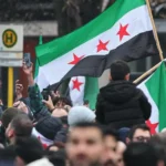 لاجئون سوريون في ألمانيا يرفعون العلم السوري