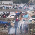 يبقى بعض المهاجرين قرب خيامهم على شاطئ "إل ترامبولين" في الجيب الإسباني سبتة، في الثاني من سبتمبر عام 2026.